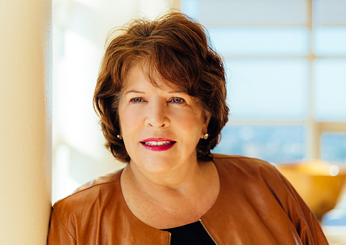 Kathy Walters leaning on post in front of a window